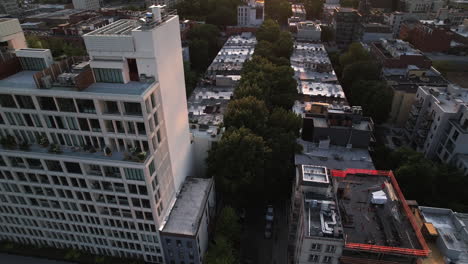 vista aérea de calles iluminadas por el sol y un apartamento de lujo, puesta de sol en brooklyn, nueva york, ee.uu.
