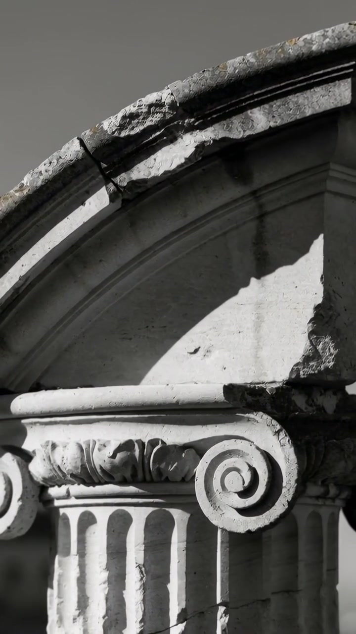 Vertical video: Initiating camera pan revealing Ionic capital at facade, capturing volutes, erosion