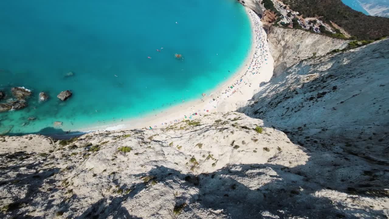 FPV dive Aerial drone video of popular paradise deep turquoise beach of Porto Katsiki with white steep rocky seascape and beautiful cloudy landscape, Lefkada island, Ionian, Greece