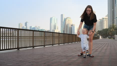 En-Verano,-Una-Joven-Madre-Caminando-Con-Un-Niño-Por-El-Paseo-Marítimo.