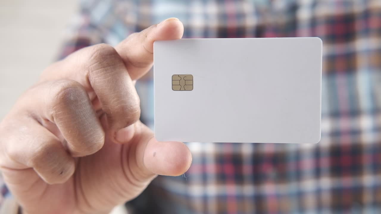 Hand holding a blank white credit card