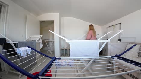 woman hanging laundry indoors