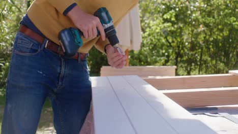 the worker drills the screws into the marks