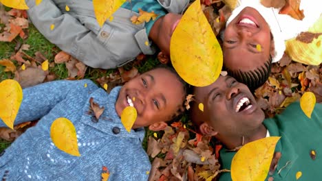 Animation-of-autumn-leaves-falling-over-happy-african-american-family-in-park