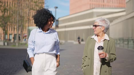 Two women walking and talking in the city