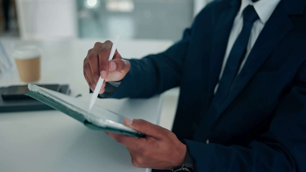 Close up of a person using a tablet with a digital pen in an office setting