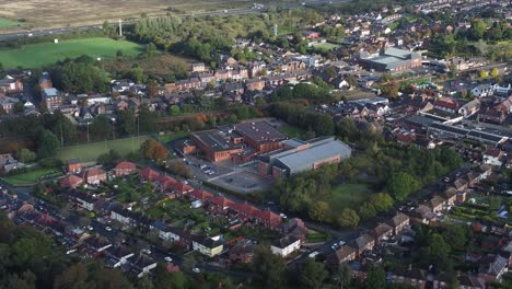 Lush-green-British-suburb-neighbourhood-alongside-M56-motorway-aerial-pull-away