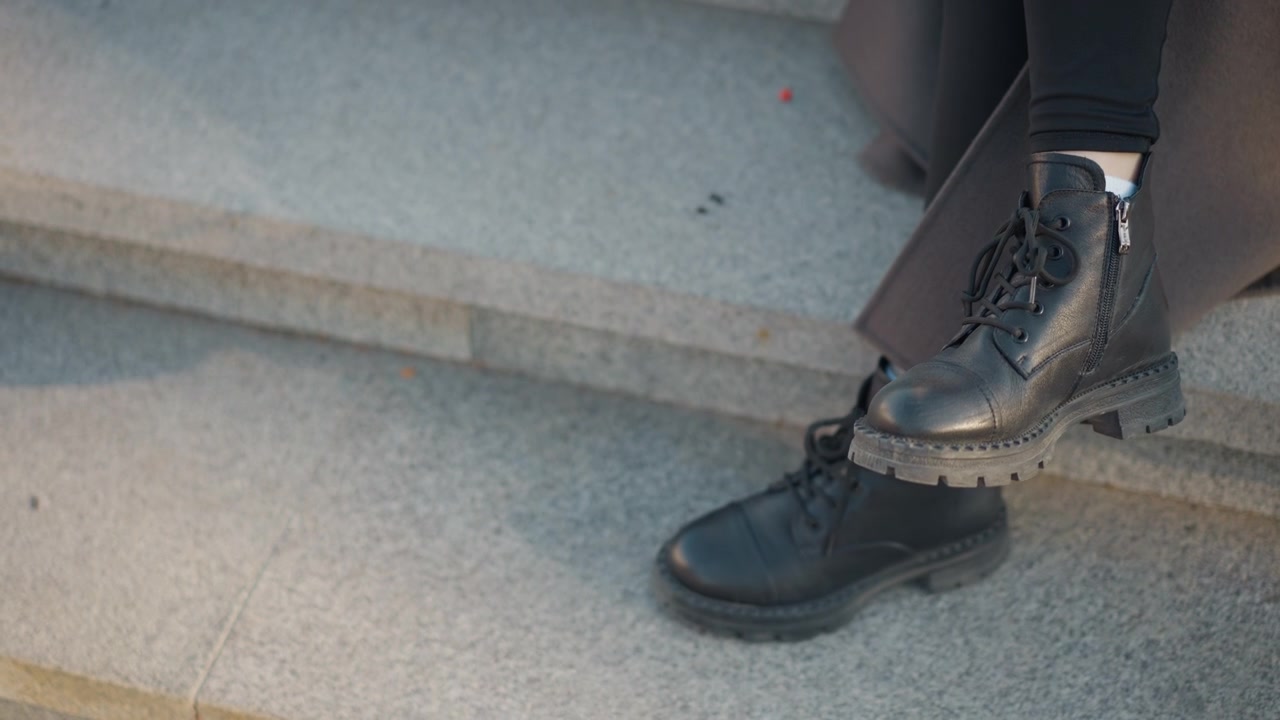 Person Wearing Black Leather Boots Sitting on Stone Steps