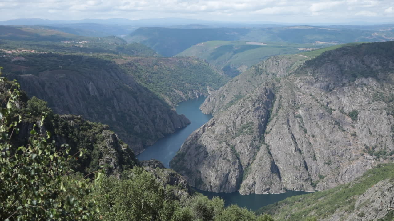Scenic mountain canyon with river view on a sunny day under a partly cloudy sky