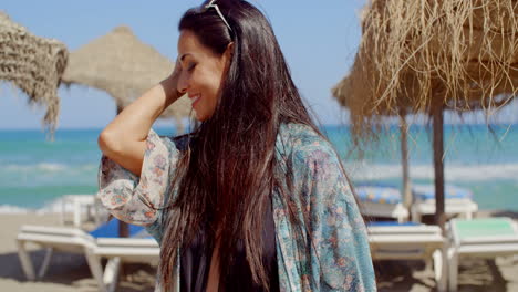 Mujer-Sonriente-En-La-Playa-Mirando-A-La-Cámara