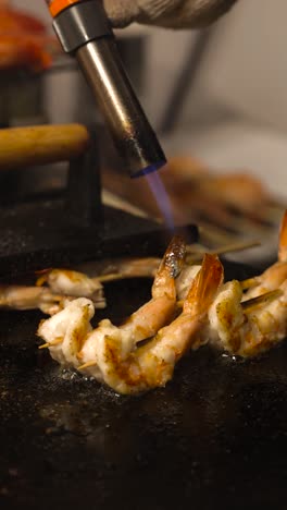 chef grilling shrimp over open flame