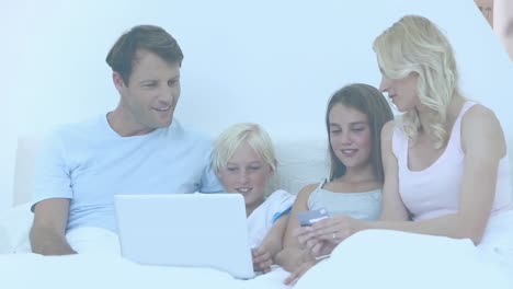 video of couple with son and daughter paying online with credit card using laptop
