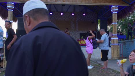 tiro de ángulo bajo de un vocalista masculino cantando una canción con pasión en un escenario en el mercado flotante de khlong hae en la provincia de songkhla, tailandia