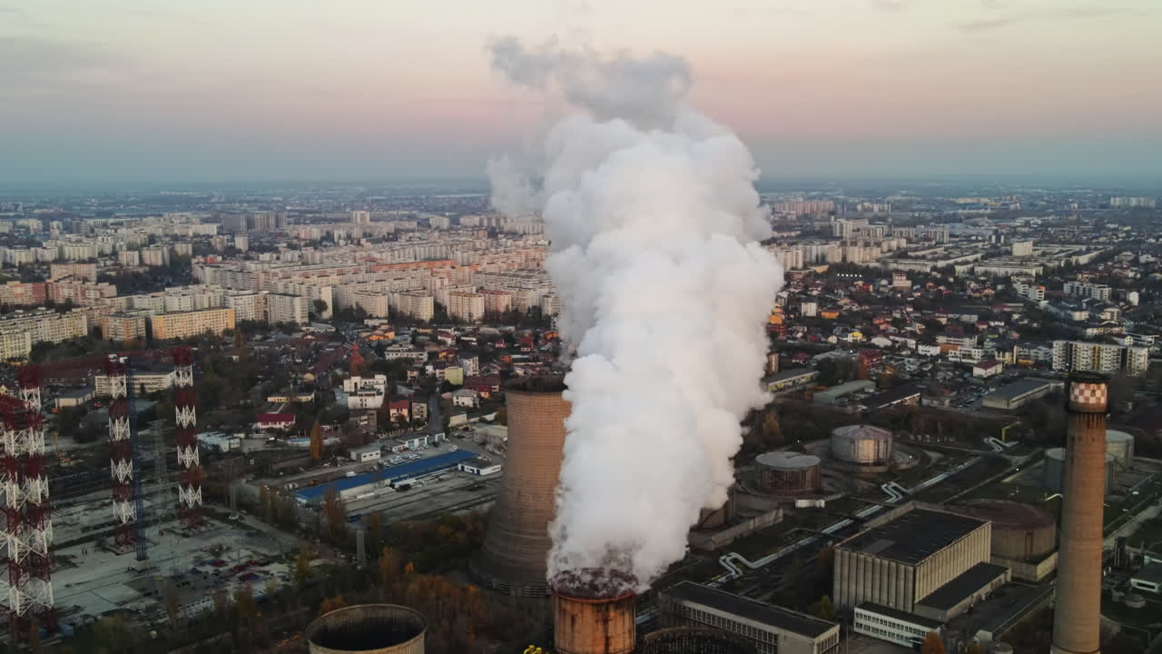 Power station with a lot of tubes and facilities in Bucharest at sunset, a lot of foam from inside a tube. cityscape, view from the drone, Romania
