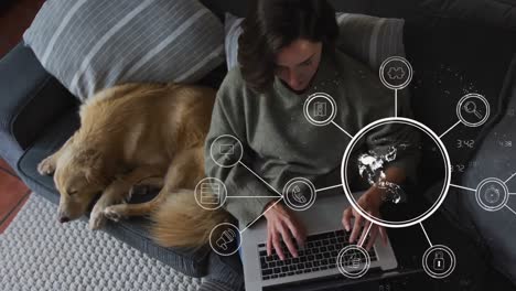 animation of media icons and globe over caucasian woman using laptop