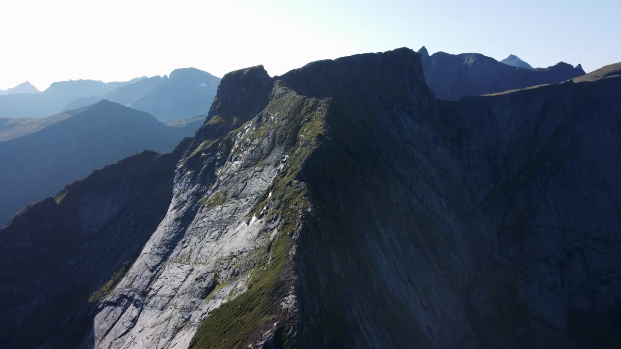 Volando sopra la cresta di una montagna, guardando le montagne sullo sfondo, quindi abbassando la telecamera verso la cresta