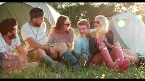 Group-Of-Friends-Relaxing-Outside-Tents-On-Camping-Holiday