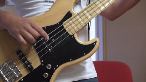 primer plano de un bajista y su estilo de dedo, detalle de cuerdas