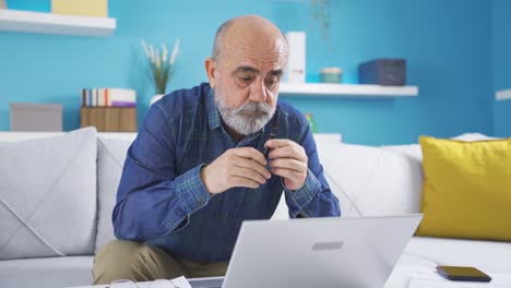 Thoughtful-old-man-looking-at-laptop.