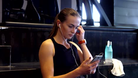 a beautiful girl turns on music in headphones before doing sports