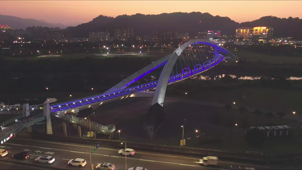 vista aérea del tráfico en la autopista y el puente de iluminación azul con gente caminando en la ciudad de taipei durante la hora dorada