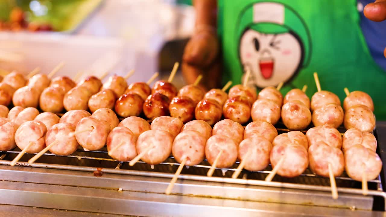 vendedor asando salchichas en un puesto de mercado flotante