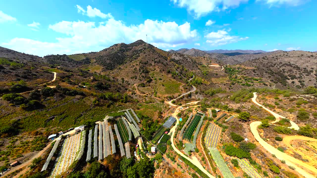 Breathtaking view of rolling mountains under a bright blue sky. Lush greenery contrasts with rocky paths, creating a stunning natural landscape perfect for hiking and exploration