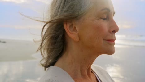 Active-senior-Caucasian-woman-standing-on-the-beach-4k