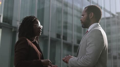 smiling colleagues shaking hands and talking