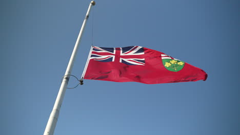 ontario flag at half-mast. flapping. super slow motion