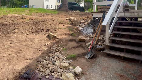 Pile-of-rock,-retiring-wall,-porch,-and-dirt-staircase-yard-project