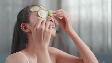 woman applying cucumber facial mask