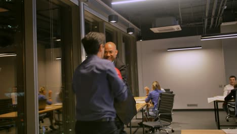 dos hombres de negocios competitivos luchando con guantes de boxeo en la oficina corporativa