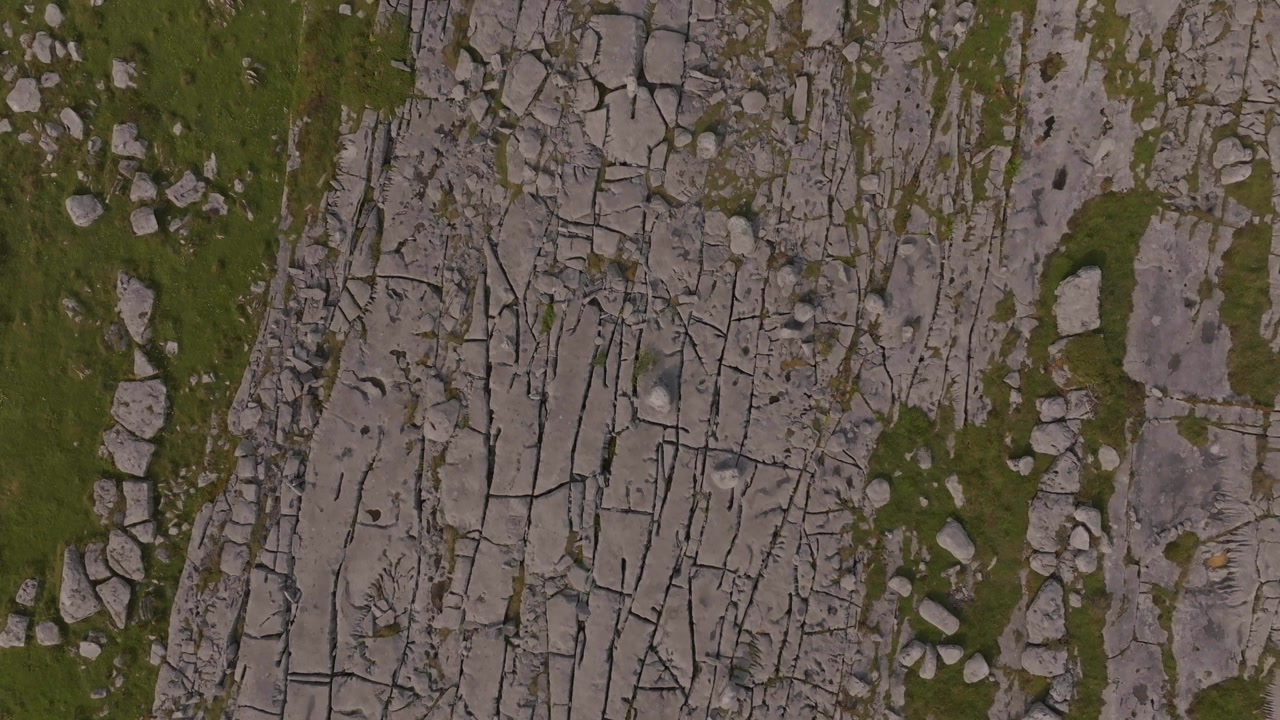 A high angle top down shot of the unique karst limestone landscape in The Burren, County Clare, Ireland. Showcases natural geological patterns and ecofriendly tourism.