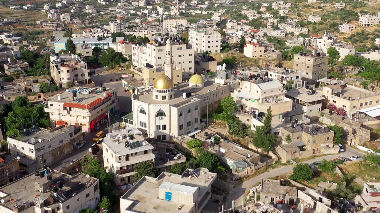 Aerial view of a densely populated Middle Eastern town with a prominent mosque