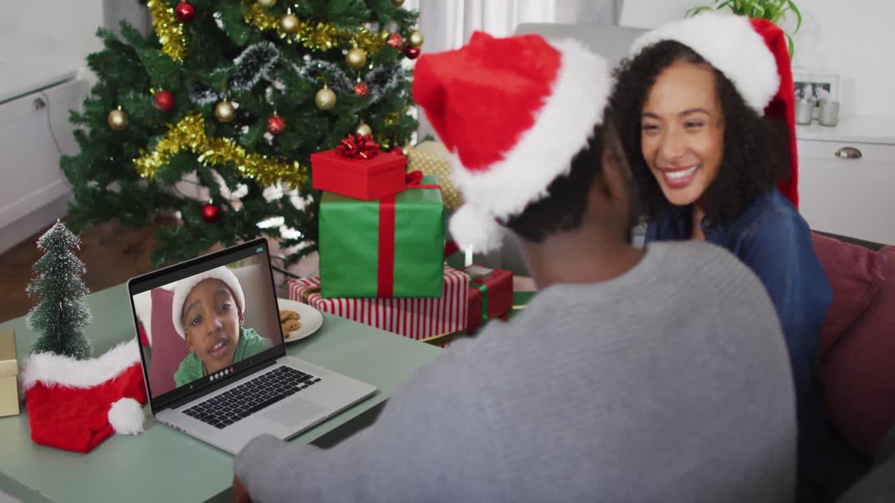 feliz pareja afroamericana en videoconferencia con su hijo en la época de navidad