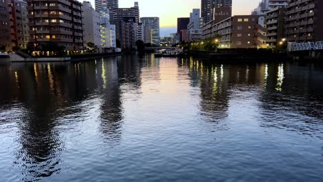 reflections of city lights on calm water at dusk