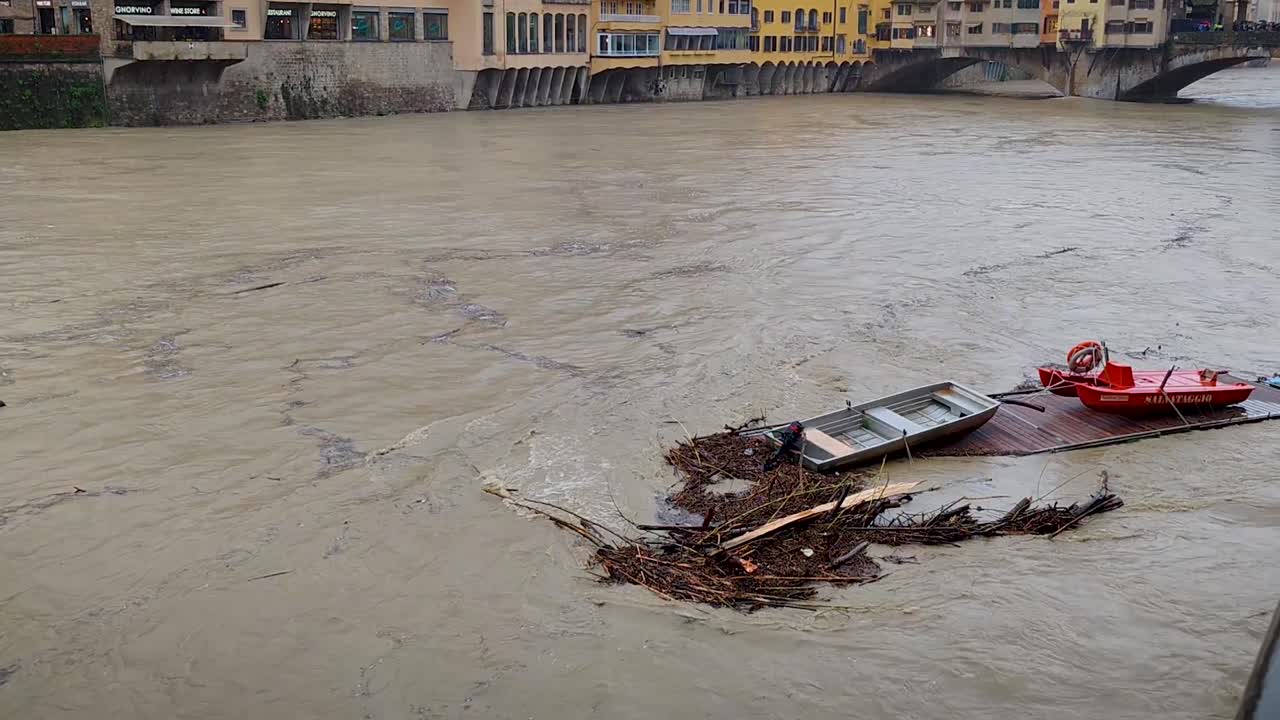 Inquadratura statica del fiume Arno a rischio esondazione, con conseguente attivazione di allarmi nei pressi di Ponte Vecchio e della Galleria degli Uffizi a Firenze, Italia