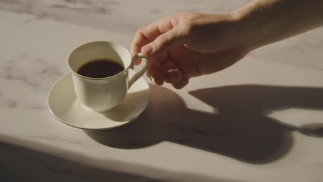 studio shot of person drinking traditional british cup of black tea from cup and saucer 1