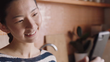 young asian woman having video chat holding smartphone using sign language chatting to deaf friend on mobile phone at home