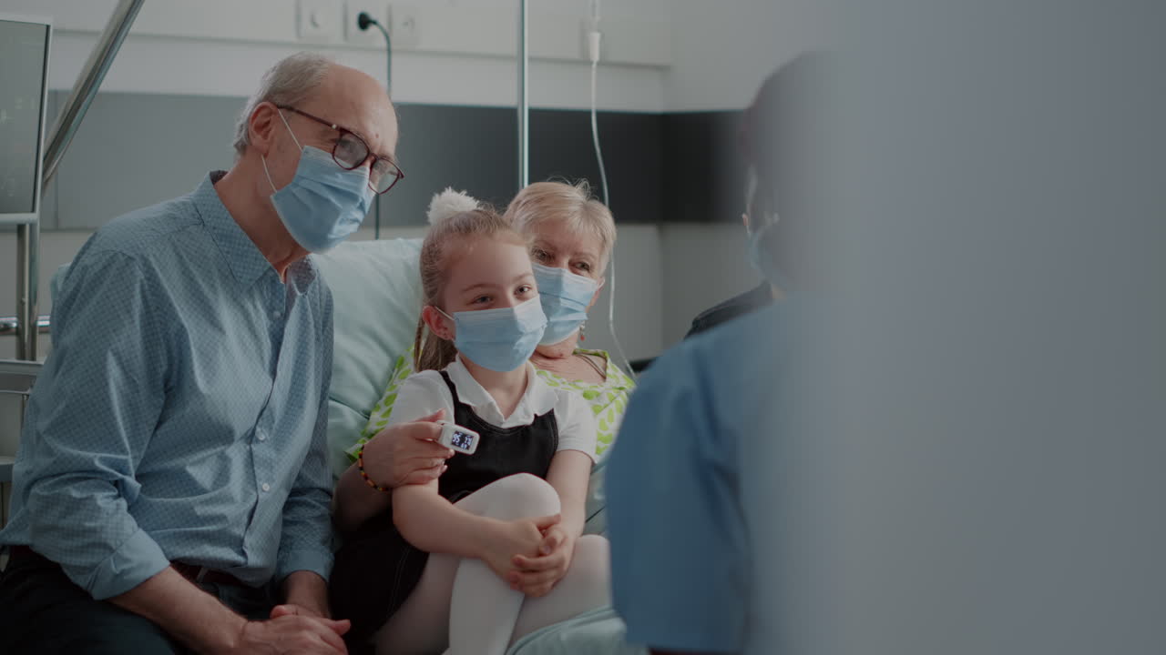 Nurse giving recovery advice to patient and visitors with face mask