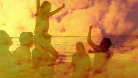 Group-of-friends-dancing-on-the-beach-during-sunset