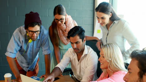 Businesspeople-having-a-discussion-while-using-laptop