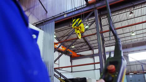 male engineer operating hoist machine in workshop 4k