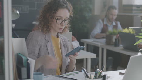 woman in the office working on mobile phone