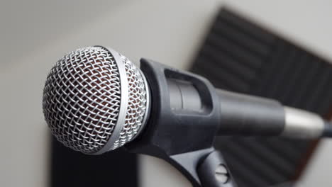 close up on a music bedroom studio vocal microphone during a podcast recording session with a pop filter