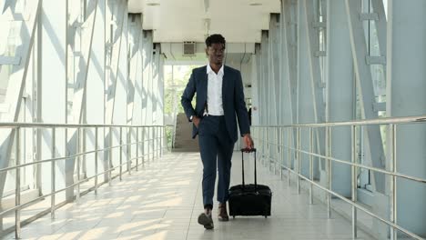 businessman pulling luggage at airport