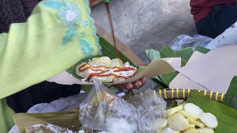 giving liquid javanese sugar topping to the delicious lupis cake