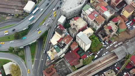 aerial top down view of yellow taxi cabs crossing a interconnected highway loop surrounded by old european buildings in istanbul turkey on a cloudy day