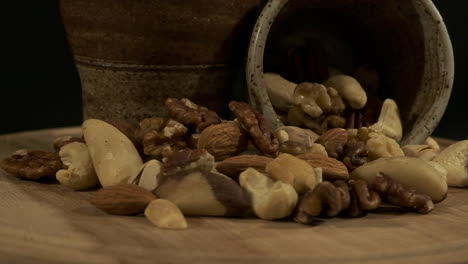 close-up low angle view of mixed nuts revolve on wooden board